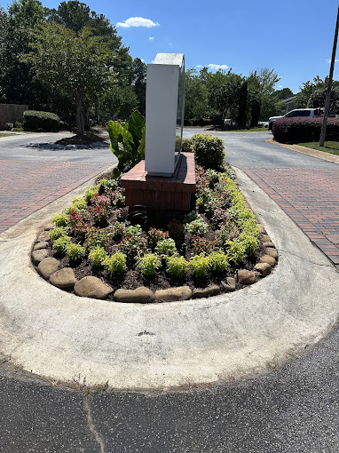 A clock in the middle of a flower bed