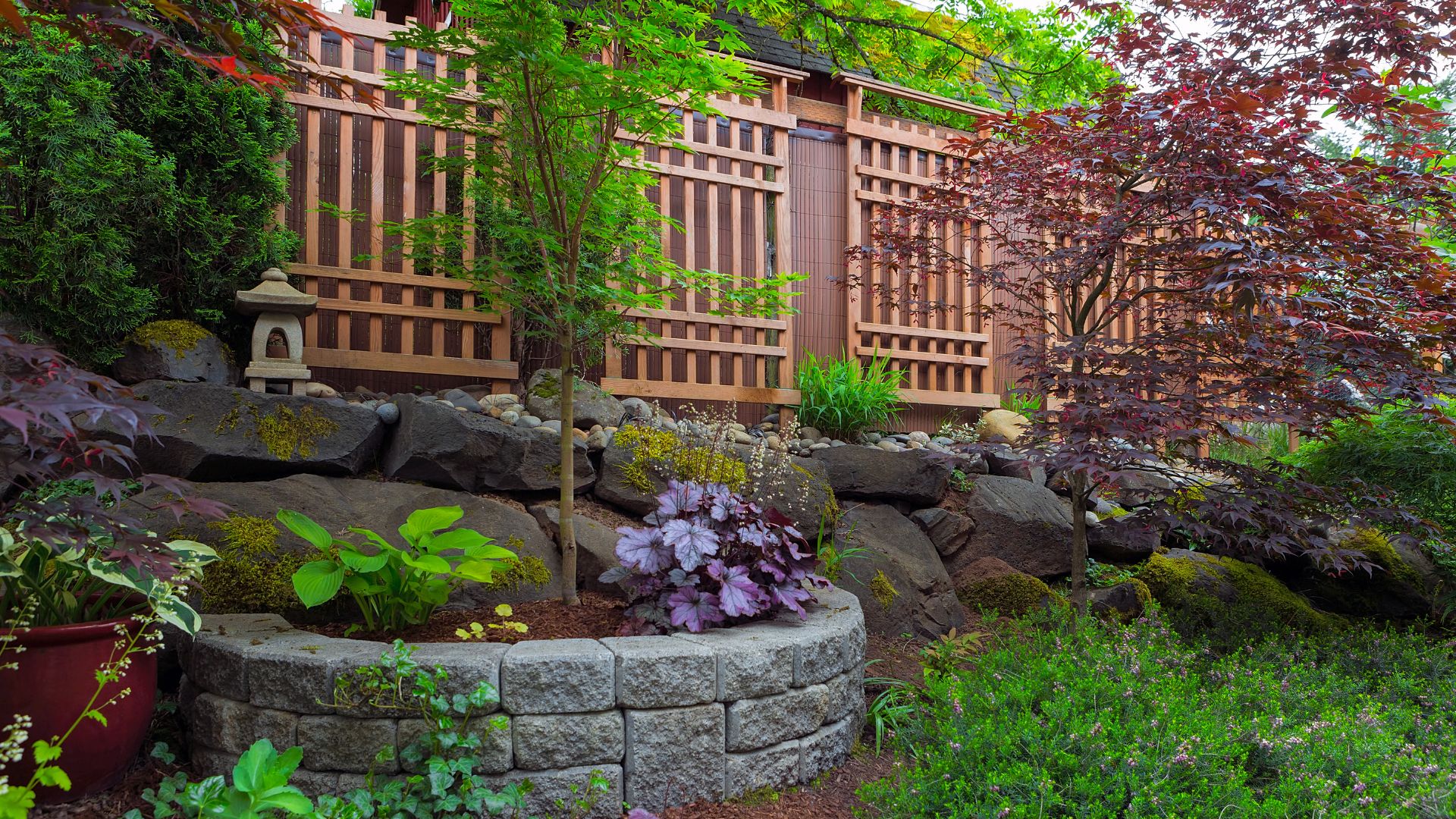 A garden with a rock wall and trees